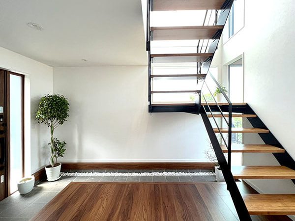 施工例27_壁を作らないスケルトン階段は空間を圧迫せず、階段ホールの窓から射す光とともに、玄関をより明るく・広く感じさせます。